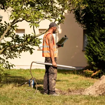 Techniker arbeitet im Garten am Glasfaseranschluss.